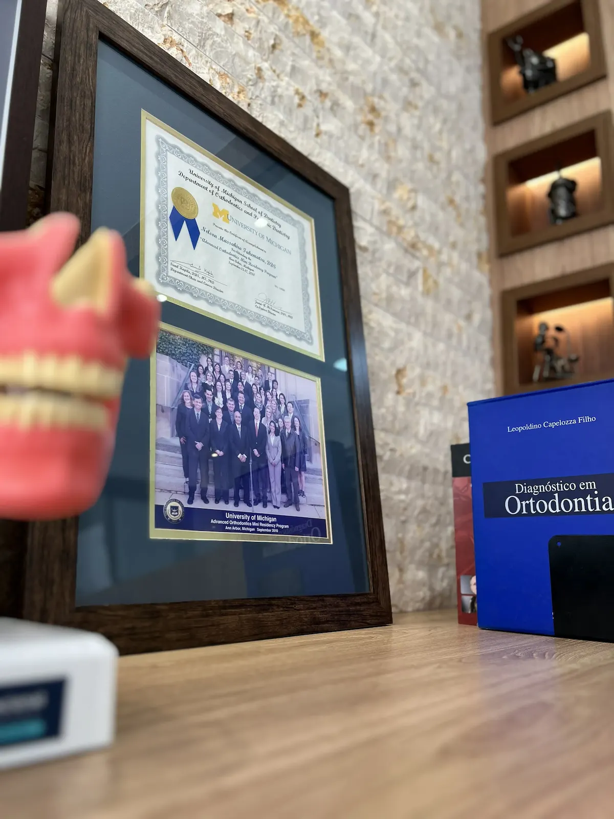 Diploma do Advanced Orthodontics Mini Residency Program — University of Michigan, emoldurado na entrada da clínica do Dr. Nelson Takematsu